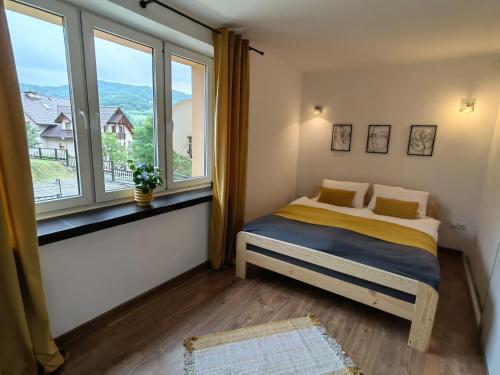una camera da letto con un letto e una grande finestra di Apartament 20tka a Szczawnica