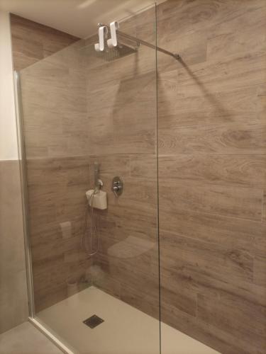 a shower with a glass door in a bathroom at Mirasole Holiday House in Leggiuno