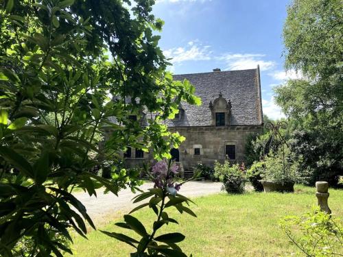 an old stone house in the middle of a yard at La Forge De La Coudraie in Pleugueneuc