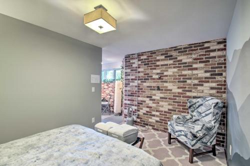 a bedroom with a brick wall and a bed and a chair at Renovated Studio on 5 Acres - Near Vineyards! in Crozet