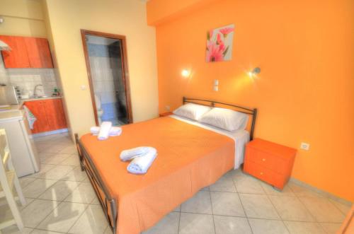 a bedroom with a bed with two towels on it at Mermaid Pool Studios and Bar in Paleokastritsa