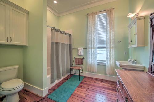 a bathroom with a toilet and a sink and a window at Charming DeFuniak Apartment in Historic Dtwn! in DeFuniak Springs