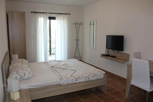 - une chambre avec un lit et une télévision dans l'établissement Villa Malina new, à Tivat