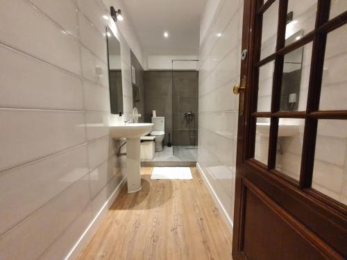 a bathroom with a sink and a toilet and a door at Castilho 63 Hostel & Suites in Lisbon