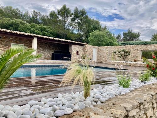une piscine avec des rochers et une maison dans l'établissement Magnifique villa de luxe au coeur de la garrigue, à Nîmes