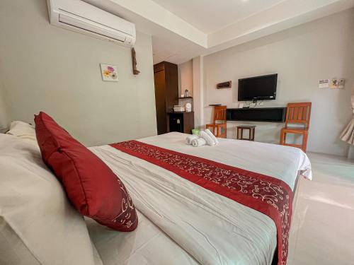 1 dormitorio con 1 cama grande con almohadas rojas en Naiyang Boutique Resort en Ban Phak Chit