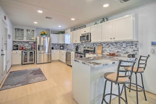 a kitchen with white cabinets and a counter with two bar stools at Waterfront Onalaska Retreat with Private Dock! in Blanchard