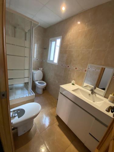 ein Badezimmer mit einem weißen Waschbecken und einer Toilette in der Unterkunft Almudafer in Puerto de Sagunto