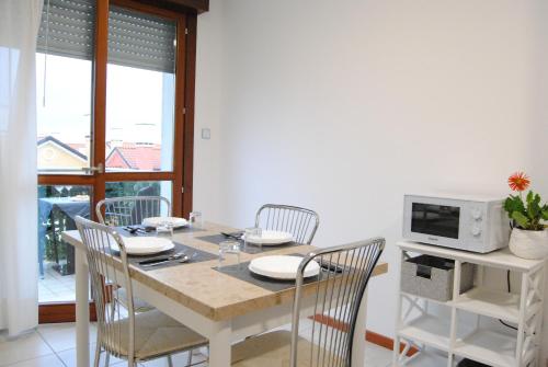 a dining room with a table with chairs and a microwave at appartamento ai do mori in Cavallino-Treporti