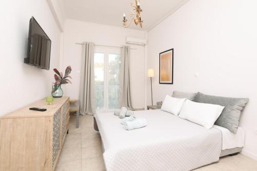 a living room with a white couch and a table at Terranova beach apartments - Jasmine in Ýpsos