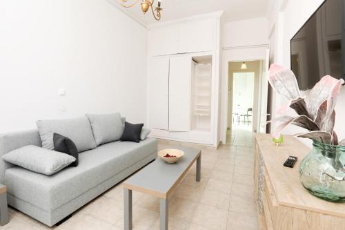 a living room with a couch and a table at Terranova beach apartments - Jasmine in Ýpsos