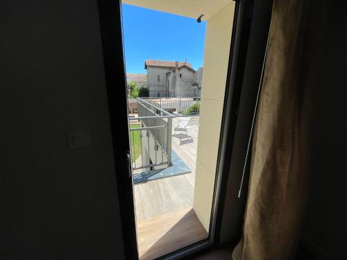 a window with a view of a balcony at La Maison de l'Olivier in Avignon