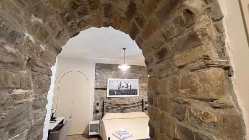 Pokój z łóżkiem w kamiennej ścianie w obiekcie Locanda Badia Residenze Iride e Celeste w mieście Castellabate