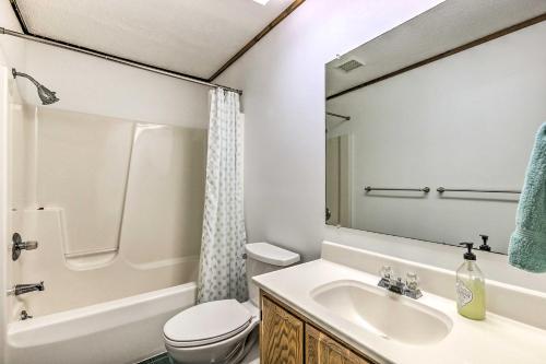 a bathroom with a sink and a toilet and a mirror at Waterfront Glenn Lake Condo Gas Grill and Views in Glen Arbor