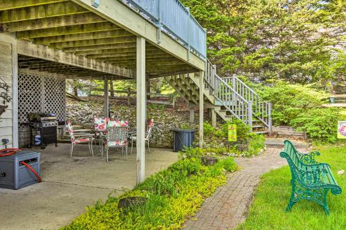 a patio with a deck and a table and chairs at Waterfront Glenn Lake Condo Gas Grill and Views in Glen Arbor