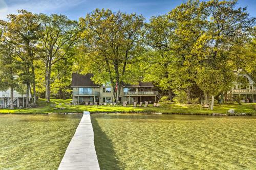 a house on a lake with a wooden dock at Waterfront Glenn Lake Condo Gas Grill and Views in Glen Arbor
