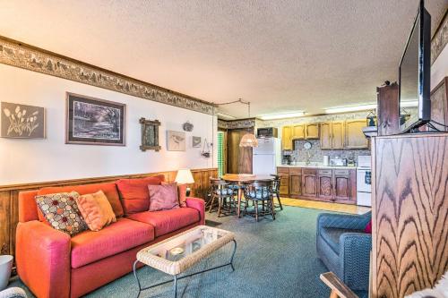 グレンアーバーにあるLakefront Glen Arbor Condo with Boat Dock Access!の赤いソファとキッチンのあるリビングルーム