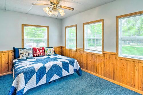 een slaapkamer met een bed en een plafondventilator bij Historic Cabin Retreat Steps to Okoboji Lake in Arnolds Park