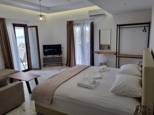a bedroom with a large bed and a living room at MANGO Skiathos in Skiathos Town