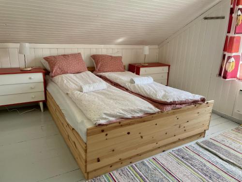 a bedroom with two beds and two night stands at Grandmothers cosy Farmhouse in Fredvang