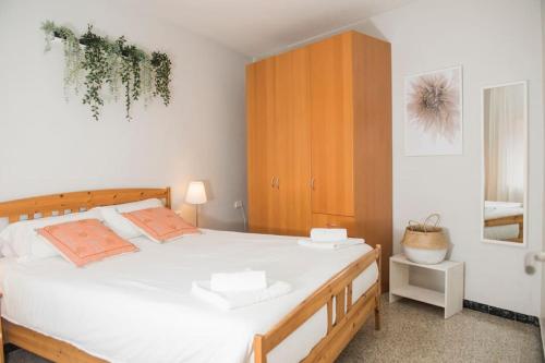 バルセロナにあるSunny and Quiet Sagrada Familiaの白いベッドと木製キャビネット付きのベッドルーム1室が備わります。