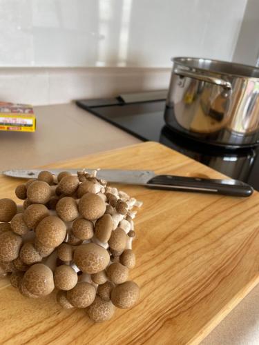 a pile of mushrooms on a cutting board with a knife at TOYA LAKEHILL CABIN - The lake view cabin at Lake Toya in Lake Toya