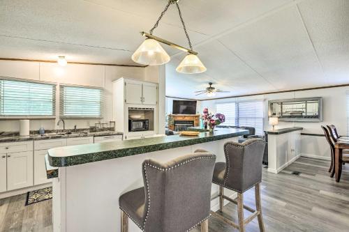 a kitchen with white cabinets and a bar with chairs at Charming Countryside Home with Covered Porch! in Livingston
