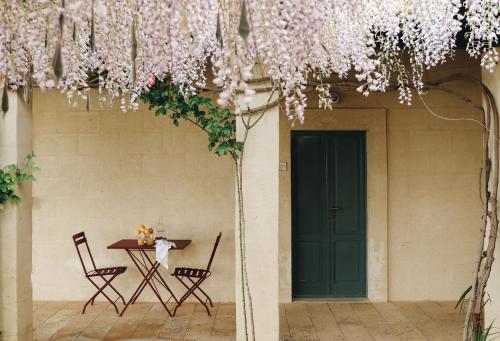 a table and chairs in a courtyard with a green door at Borgo Valle Rita in Ginosa Marina