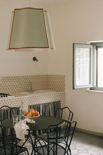 a table and chairs with a bowl of fruit on it at Borgo Valle Rita in Ginosa Marina