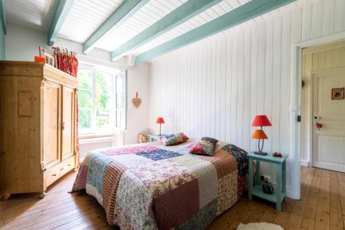 une chambre avec un lit et une grande fenêtre dans l'établissement Maison Bellini, à Plouër-sur-Rance