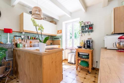 - une cuisine avec un îlot en bois dans l'établissement Maison Bellini, à Plouër-sur-Rance