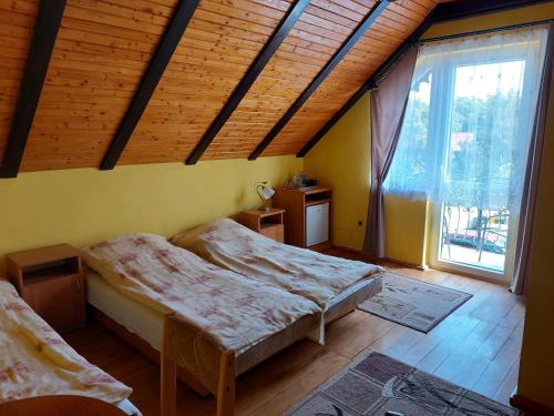 ヤストシェンビャ・グラにあるPokoje Goscinne Anna Mariaのベッドルーム1室(ベッド2台、大きな窓付)