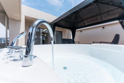 a sink with two faucets on a bath tub at Oshiage Sky View Terrace Penthouse in Tokyo