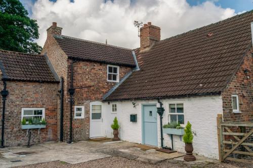 an old brick house with a blue door and windows at Carlton Towers in Carlton