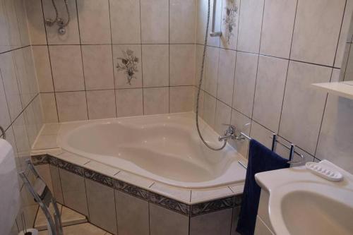 a bath tub in a bathroom with a sink at Apartman Carsko in Rijeka