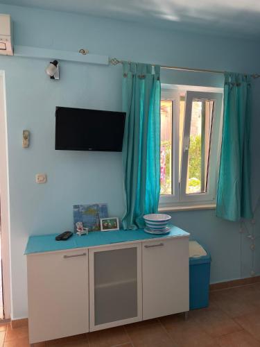 a living room with a tv on the wall and a table at Apartments Panda in Bol