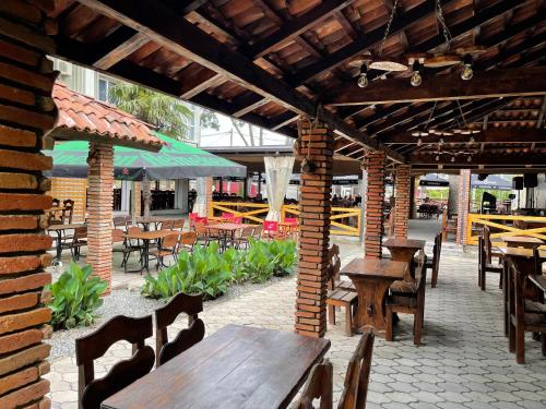 an outdoor patio with wooden tables and chairs and tables at Hotel Orbita Ureki in Ureki