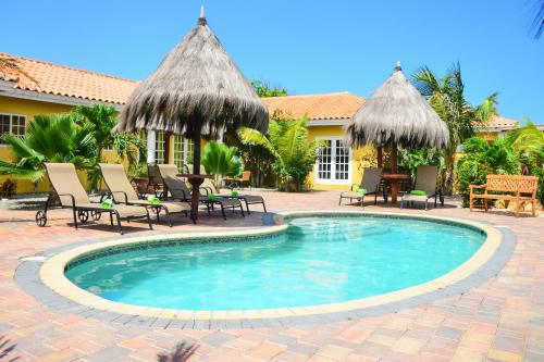 a swimming pool in front of a house at Aruba Tropic Apartments in Noord