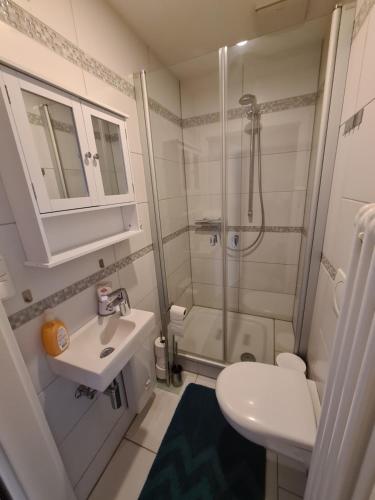 a white bathroom with a shower and a sink at Ferienwohnung Fellnasen WG in Krefeld