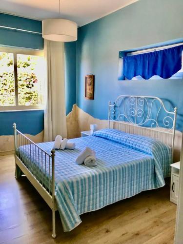 a blue bedroom with a bed with towels on it at B&B Villa Dunardi in Fontane Bianche