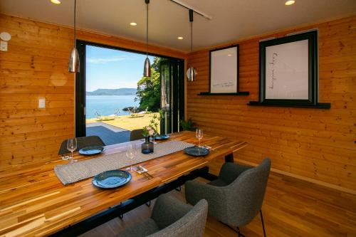 a dining room with a table and chairs and a large window at 佐世保VILLA青鹿Ur1 in Sasebo