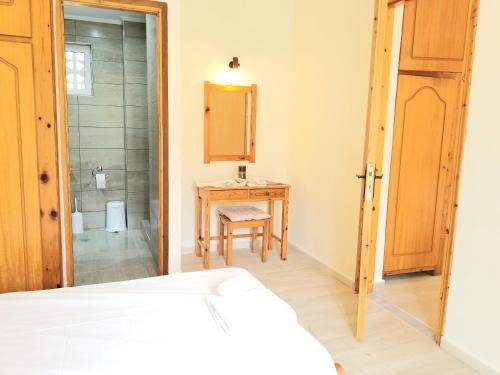a bedroom with a bed and a table and a mirror at Corfu Escape Five ( Leonidas Studios) in Agios Georgios Pagon