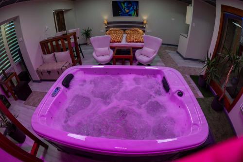 a pink bath tub in a living room with a table at E 14 in Berekfürdő