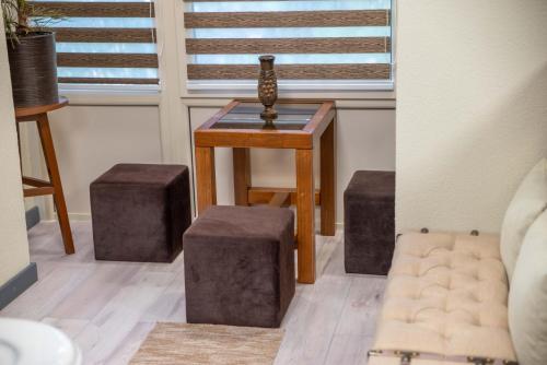 a room with a table with stools and a vase on it at E 14 in Berekfürdő
