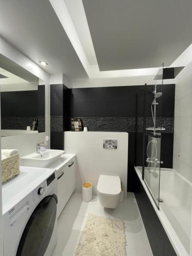 La salle de bains est pourvue d'un lavabo, de toilettes et d'une douche. dans l'établissement Ogród Victorii - Apartament z dużym ogrodem, tarasem i altaną, à Gdańsk