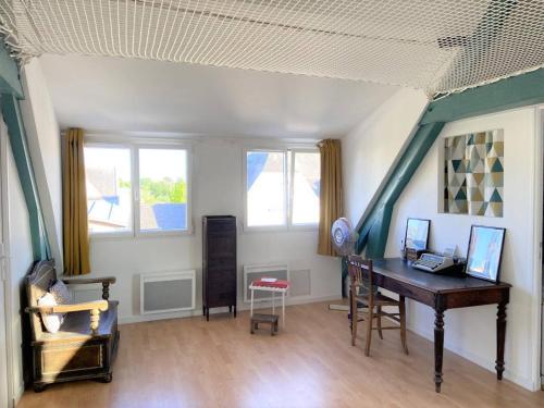 an attic room with a desk and some windows at Maison rénovée 3 étoiles à 150m de la plage, idéale pour familles avec espace enfants et Wifi - FR-1-481-116 in Bénodet