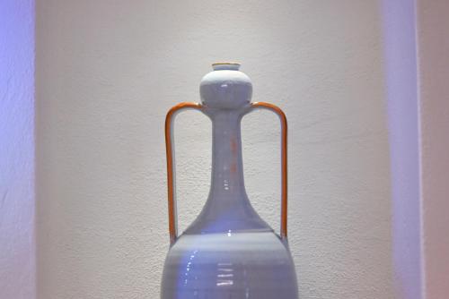 a blue glass vase sitting next to a wall at Pietra Bianca Luxury Suite Ostuni in Ostuni