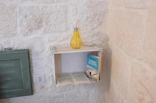 a book shelf on a wall with a yellow vase at Pietra Bianca Luxury Suite Ostuni in Ostuni