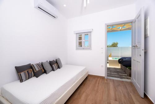 sala de estar blanca con sofá blanco y ventana en Kasteli Suites, en Perivolos