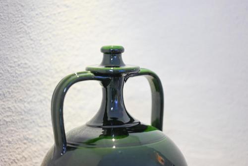 a green glass vase sitting on a table at Pietra Bianca Luxury Suite Ostuni in Ostuni